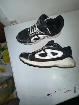 B30 sneakers - Säljer ett par svarta  B30 sneakers med vita detaljer och reflekterande logga på sidorna. Skorna har mesh och syntetmaterial, vita snören och en chunky sula i svart och vitt. Perfekt för dig som vill ha en sportig och lyxig vibe i din outfit. Självklart så rengörs allt innan den fraktas ut.