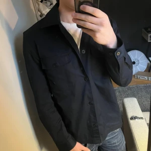Marin blå overshirt  - Tjena! Säljer nu denna otroligt feta overshirten från mango köpte den i sommaren men har inte använt den något. Skick: helt ny   Storlek: S