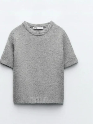 Kortärmad ljusgrå stickad tröja  - En enkel kortärmad ljusgrå stickad tröja från Zara storlek M. Tröjan är liten för sin storlek. (Jag är storlek XS) Aldrig använd.