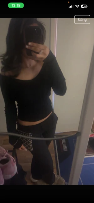 Svart offshoulder långärmad topp - Säljer en svart långärmad topp med offshoulder-modell. Toppen är croppad och har en tight passform som framhäver axlarna. Perfekt för dig som gillar en stilren och enkel look.