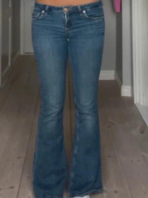 Blå bootcut jeans med låg midja - Säljer mina jättefina Lågmidjade bootcut jena från BDG. De är i bra skick och är väldigt trendiga, lite slitna i rumpan men inget som märks! Storlek 27/32 och passar mig som har i vanliga fall S. Kontakta vid frågor!🥰