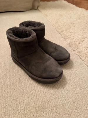 Uggs skor - Ett par äkta uggs skor i svart som är väld använda. Storlek 36.  De är billiga eftersom de inte är i perfekt skick.