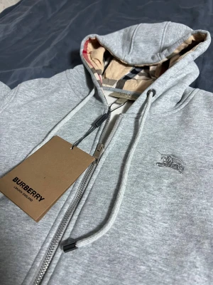 Burberry kofta - Säljer denna koftan från burberry. Den är använd endast en gång och säljer den då den är för lite för mig. Jag är 172 och 75kg och tröjan är storlek S. Skriv till mig om du har några frågor!