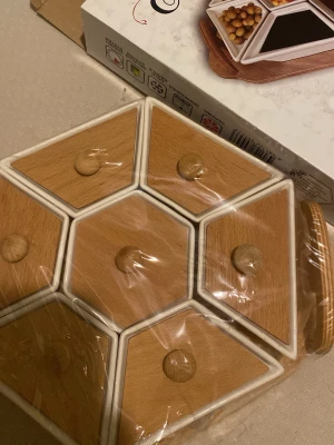 Ingen väst på bilden - Bilden visar ingen väst, utan en förvaringslåda eller snacksbricka i trä och keramik. Ingen information om väst kan ges.