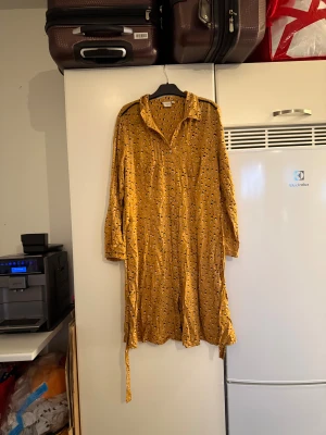 Senapsgul leopardmönstrad klänning Cream - Senapsgul skjortklänning från Cream i storlek 38. Klänningen har leopardmönster i svart och ljusrosa, knappar framtill, krage och långa ärmar. Tillhörande bälte i midjan för extra passform. Perfekt för dig som gillar djurmönster och vill sticka ut. Storlek 38/M. Mer använd men fortfarande fint skick. 