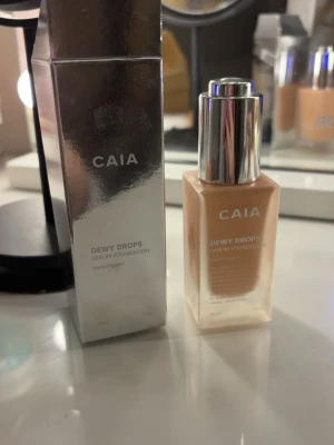 CAIA Dewy Drops Serum Foundation 20C - CAIA Dewy Drops Serum Foundation i nyansen 20C. Kommer i en snygg frostad glasflaska med silvrig pump och tillhörande förpackning. Foundationen har en ljus, neutral ton och ger ett fräscht, naturligt glow. Innehåller 30 ml.