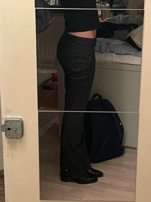 Svarta lowwaisted byxor  med dragkedjor - Säljer ett par svarta byxor  med låg midja och raka ben. Byxorna har snygga dragkedjor vid fickorna och dubbla knappar i midjan. Perfekta för dig som vill ha en stilren look med sportig känsla. Det är inte läder byxor eller fakeläder utan mer styva i materiallet! Helt ny skick då hag kanppt användt dem! 