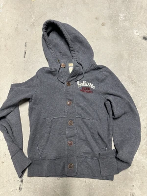 Vintage Hollister kofta med knappar  - Extremt eftertraktad och sällsynt vintage  Hollister hoodie med knappar! Grymt skick, inga defekter - ser exakt ut som på bild! Storlek S!. Skriv vid frågor!💬