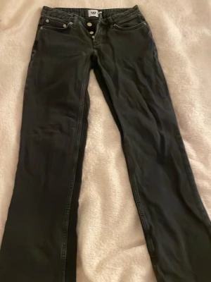 Lager 157 svarta jeans straight fit - Klassiska svarta Lager 157 jeans med raka ben och knappgylf. Jeansen har fyra fickor och är tillverkade i slitstarkt bomullsjeansmaterial. Perfekta för en clean och tidlös look.