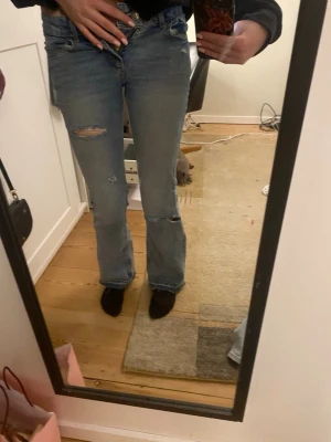 Ljusblå bootcut jeans - Ljusblå jeans med bootcut passform, låg midja och slitna detaljer. Älskar dem men tyvärr har de blivit försmå!