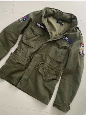 Ralph Lauren field jacket - Hej säljer min gröna fieldjacka från ralph Lauren den är i nyskick och ny pris ligger på runt 5500kr .  Jackan är i strl xs, fit S/M, modellen är 176 och den kommer passa perfekt nu till våren! Skriv vid bilder eller frågor, vid snabbaffär=bättre pris