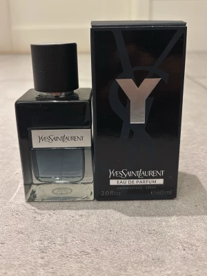 Yves Saint Laurent Y Eau de Parfum - Y Eau de Parfum från Yves Saint Laurent i en stilren, mörk glasflaska med svart kork och silverdetaljer. Flaskan rymmer 60 ml och kommer med originalkartong i svart med stor Y-logga. En ikonisk doft för dig som gillar exklusiva parfymer.