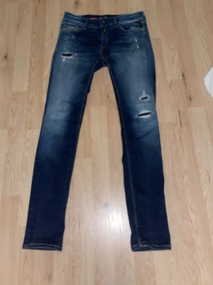 Replay jeans - Säljer ett par feta mörkblåa replay hyperflex jeans med slitningar. De sitter lite tighta vid låren men är ändå väldigt sköna att ha på sig