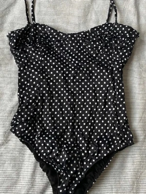 Svart prickig body med smala band Zara  - Säljer en svart body med vita prickar och tunna axelband. Sååå snygg. Storlek S men strechig så passar xs-m. Det har varit ett litet hål i tyget men har sytt igen det så är inget hål längre. Det har hänt på sidan under dragkedjan så det är verkligen inget som syns och dragkedjan funkar!!
