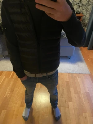 Uniqlo väst - Snygg svart dunväst från Uniqlo, passar till det mesta och är bra för att hålla dig lite  varmare. Storlek XS och jag är 174 cm på bilden. Hör av vid frågor 