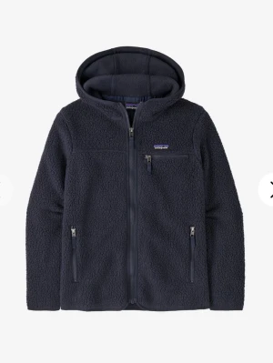 Mörkblå fleecehoodie från Patagonia - Mysig mörkblå fleecehoodie från Patagonia med hel dragkedja, huva och tre praktiska fickor med dragkedja. Perfekt för lager-på-lager och chill dagar. Klassisk logga på bröstet och mjukt teddyfoder för extra komfort.