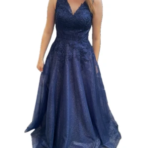 Marinblå balklänning - Elegant marinblå långklänning med glittrande tyg och v-ringad urringning. klänningen har förkortats!! Jag är 170cm☺️ Kan skicka fler bilder!