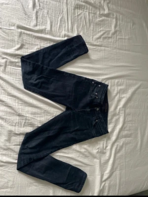 Mörkblå/svarta nudie jeans W27 L30 - Ett par snygga nudie jeans med bra passform. Bra skick också.