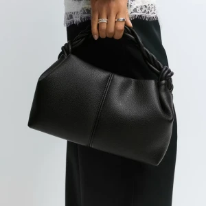 Svart handväska med tvinnat handtag - Snygg svart handväska med ett flätat handtag som en snygg detalj. Använd fåtal gånger.