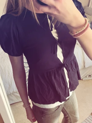 Marinblå blus med knyt och puffärm - Snygg svart blus med puffiga korta ärmar och knyt framtill. Skit snygg topp, perfekt att styla med ett vit eller svart linne under!💕