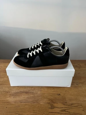 Maison Margiela Gats - Säljer dessa Svarta Maison Margiela Gats i storlek 42📏 | Testad endast några gånger | Helt autentiska, allt og på bild följer med vid köp | kvitto finns. Tveka inte på att höra av dig vid fler frågor eller funderingar 🙌.