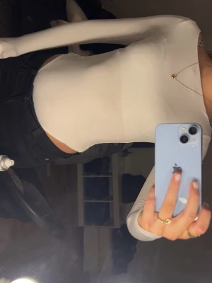 Vit långärmad topp i stretchigt material - Säljer en enkel och stilren vit långärmad topp med tight passform. Toppen är gjord i ett stretchigt, tunt material och har en rund halsringning. Perfekt att styla med jeans eller kjol för en clean look.