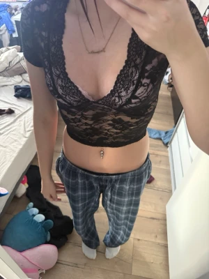 Svart croppad spetsblus med v-ringning - Säljer en svart, croppad blus i spets med korta ärmar och djup v-ringning. Toppen är använd 1 gång 💕 stolek xs.