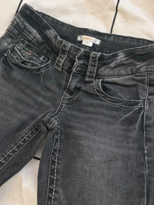 Svarta/mörkgrå bootcut jeans Gina Tricot - Snygga bootcut jeans från Gina Tricot i storlek 140. Modellen har bootcut-ben och låg midja. Säljer då de tyvärr är försmå. Jag har sprättat upp de längst ner, så de är lite längre, det är inget som syns från långt håll🥰 Skriv vid frågor, svarar snabbt🪩💫