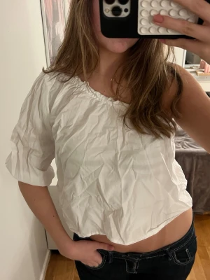 Vit oneshoulder topp från Boohoo - Säljer en vit oneshoulder topp från Boohoo i storlek 34. Toppen har en avslappnad passform med resår vid halsringningen och ena ärmen. Tillverkad i ett lätt och mjukt material som känns skönt mot huden. 