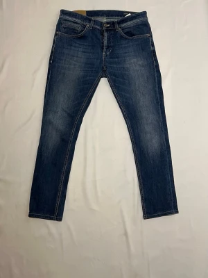 DONDUP JEANS - George - Hej! Säljer ett par riktigt snygga Dondup jeans i en ljusblå färg. Storlek 32. Modellen är George, en väldigt populär passform som sitter riktigt bra och är väldigt stilrent. Jeansen är i bra skick.  Hör gärna av er om ni har frågor! 