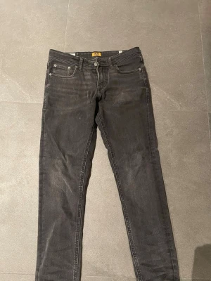 Svarta slim jeans från Jack & Jones - Säljer ett par svarta slim jeans från Jack & Jones. Jeansen har klassisk femficksdesign, hyfsat smal passform och är tillverkade i stretchigt denimtyg för extra komfort. Snyggt slitna detaljer och diskret logga på linningen. Bara skriv vid frågor👍