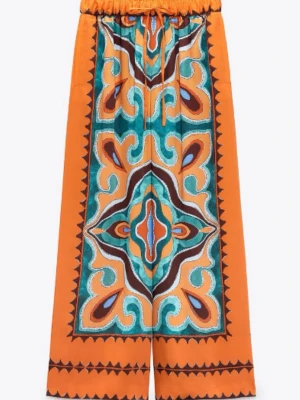 Orange mönstrade wide linnebyxor - Färgstarka linnebyxor med bred passform och unikt mönster i orange, turkos, brunt och vitt. Byxorna har snörning i midjan och ett coolt, nästan bohemiskt print som verkligen sticker ut. Perfekta för dig som vill ha något annorlunda och bekvämt.