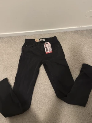 Svarta Levi's 512 jeans - Säljer ett par svarta Levi's 512 jeans med slim fit och klassisk femficksdesign. Jeansen har en snygg, smal siluett och är tillverkade i mjukt bomullsmaterial med lite stretch för extra komfort. Passar dig som gillar stilrena och moderna jeans.