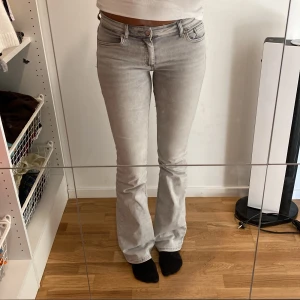 Ljusgrå bootcut jeans från Only - Säljer ett par ljusgrå jeans från Only med bootcut-modell och klassisk femficksdesign. Jeansen har låg midja och är tillverkade i mjuk denim. Perfekta om du gillar en stilren och avslappnad look.