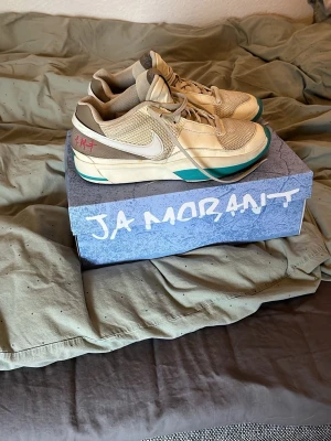 Nike Ja Morant sneakers beige/blå - Säljer ett par Nike Ja Morant sneakers i beige och ljusbrun med vita detaljer och turkosblå inslag på sulan. Detta är ett par basketskor men går att användas som sneakers även. Dom är använd max 20 gånger i ett sparsamt sätt. Finns lite små defekter på skon men inget som syns. Lådan ingår vid köpet. Skriv vid funderingar!!!
