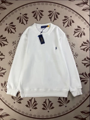 Vit sweatshirt från Polo Ralph Lauren - Snygg vit sweatshirt från Polo Ralph Lauren med klassisk rund hals och broderad logga på bröstet. Tröjan har ribbade muddar vid ärmslut och nederkant, vilket ger en stilren och bekväm passform. Perfekt för dig som gillar enkel och tidlös design.
