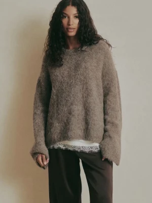 Brun fluffig stickad tröja i alpackablandning - Slutsåld oanvänd med lappen kvar!!!Supermjuk och oversized brun stickad tröja i alpackablandning. Tröjan har lång ärm, rund halsringning och en riktigt fluffig känsla. Perfekt för lager-på-lager och chill vibes.