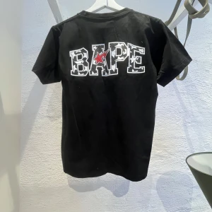 Svart BAPE t-shirt med tryck - Svart t-shirt från BAPE köpt på officiell butik i Paris. Storleken är s men kan passa xs. Skriv för eventuella frågor. Tröjan är i gott skick