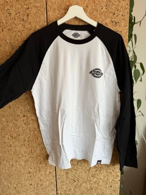 Långärmad t-shirt från Dickies - Snygg svartvit långärmad t-shirt från Dickies med tryckt logga på bröstet. Säljs då stilen inte passar mig längre.