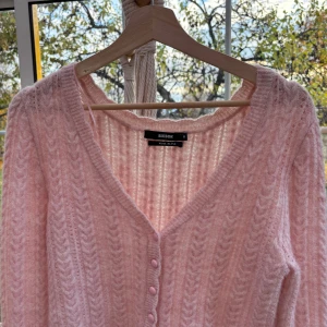 Stickad kofta - Supermysig helt oanvänd ljusrosa kofta från Bikbok i mjuk ullblandning. Koftan har ett snyggt stickat mönster, v-ringad hals och matchande rosa knappar framtill. Långärmad och croppad passform. Pris kan diskuteras 