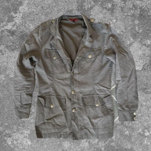 Grå Fieldjacket - Trendig och perfekt nu i höst! Måtten: A=47cm B=45cm C=50cm D=69cm