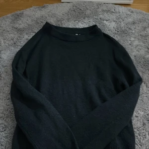 Svart stickad tröja från 157 - Mysig svart stickad tröja från 157 i storlek XS. Tröjan har en enkel design med rundad hals och långa ärmar. Perfekt för att hålla sig varm under kyliga dagar och passar till många olika stilar.