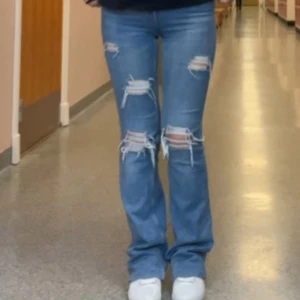 Blå bootcut jeans med slitningar - Snygga blå jeans med bootcut passform och slitna detaljer på knäna och låren. jeansen är från zara och jag har gjort hålen själv, de är i storlek 34 och är för små för mig. högmidjade med bootcut. kontakta mig för fler bilder💓