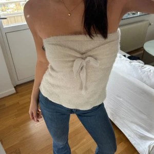 Fluffig tubtopp med snöring - LIATZ - Handgjord från Liatz, limited edition. Väldigt bra skick. Den är sydd i onesize. Men passar nog bäst XS-M. Vit/beige färg 