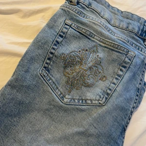 Blå jeans med broderad bakficka - Från lager 157. Snygga ljusblå jeans med en unik broderad design på bakfickan. 