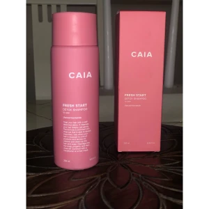 CAIA Fresh Start Detox Shampoo - Fräsch rosa flaska och kartong med CAIA Fresh Start Detox Shampoo, 250 ml. Innehåller kol och niacinamid för en djuprengörande effekt. Perfekt för dig som vill ge håret en detox och fräsch känsla. Snygg design som passar på badrumshyllan.