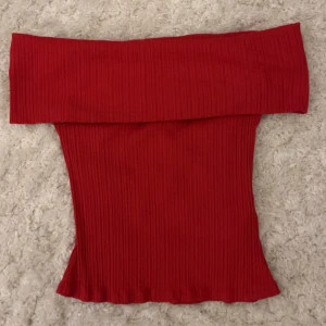 Röd ribbad offshoulder topp NA-KD - En röd ribbad off shoulder topp från NAKD som aldrig kommit till användning! Stretchig i materialet och har inga defekter❣️