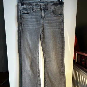Grå jeans från Gina Tricot - Snygga grå jeans från Gina Tricot Young med detaljer på fickorna, jätte fina på men säljer då de tyvärr blivit för korta! Byxorna har en fläck på knät (skriv till mig om jag ska ta detaljbild på det) men skulle gå bort ifall man använde fläckborttagning💕 Skriv ifall ni har evelat se fler bilder på jeansen🫶 storlek 158 men av någon anledning gick det inte att ta här på plick!