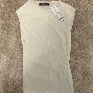 Vit topp från Ginatricot  - Varan är aldrig använd. Prislappen sorter fortfarande kvar. Det är en väldigt fin topp. Självaste modellen är lite genomskinlig.