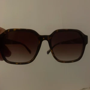 Bruna fyrkantiga solglasögon - Snygga solglasögon från Prestige med fyrkantig form och bruntonade glas. Bågarna har ett coolt sköldpaddsmönster i brunt och gult, vilket ger en trendig vibe. Perfekta för soliga dagar och en stilren look.